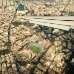 Flugzeug Fliegen über den Wolken Stadt von oben Stadion